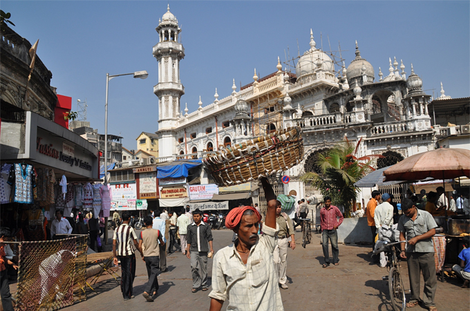 Templos suntuosos y pequeños comerciantes en una calle de Mumbai